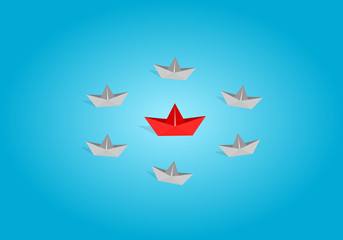 Red origami paper boat leading gray staff ones go on the route on blue background. Leadership and teamwork concept.