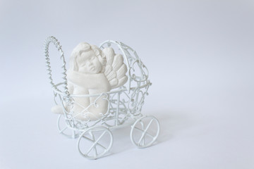 Sweet love sleeping baby angel decoration into pram on white background