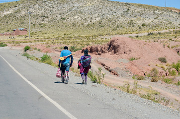 Road view with two people walking and mountains in the surroundings of Macha, Potosi, Bolivia