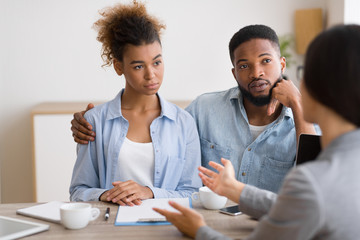 Serious Black Couple Listening To Financial Advisor During Investment Consultation