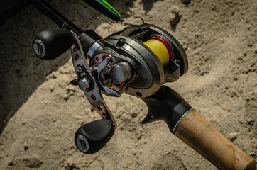 Fishing from the shore. Rigged up baitcasting reel ready to catch a pike. Close-up