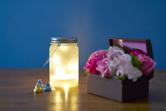 Chocolates with lanterns and small flower baskets on an outdoor table.