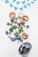 Oktoberfest composition with traditional Bavarian white blue fabric , decoration, pretzel , cups of...