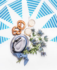 Oktoberfest layout with traditional Bavarian white blue fabric,  pretzel , cups of draft beer,...