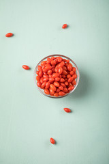 Frische Goji-Beeren Superfood in Glas Schale auf Mint Grün Pastell Hintergrund