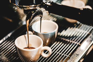 Espresso machine brewing a coffee. Coffee pouring into glasses in coffee shop, espresso pouring from coffee machine