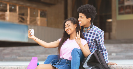 Fototapeta na wymiar Young couple smiling and taking selfie outdoors