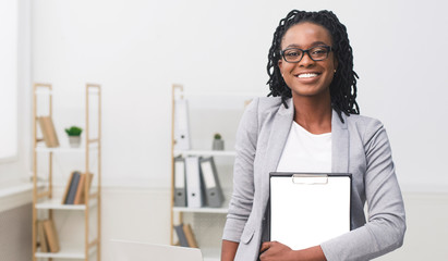 African American Businesswoman Holding Folder Smiling At Camera In Office
