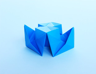 Blue paper boat on a blue background.