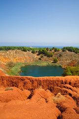 Fototapeta na wymiar Bauxite Cave of Otranto in Apulia, Salento, Italy. The digging was filled with natural waters. Red soils quarry cave 