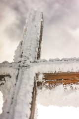 frozen cross in the snow on a mountain peak