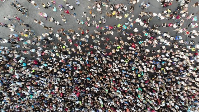 Aerial. People crowd on a city square. Mass gathering of many people in one place. Top view from drone fly. 