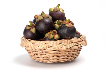 Mangosteens in a basket placed on white background, Pile of mangosteens in a basket placed