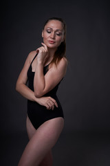 Obraz premium flexible sexy girl poses on a black grey background in the fitting clothes baud