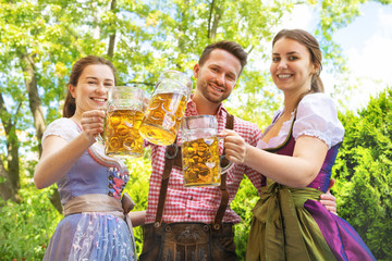 Young people in Tracht, Dindl and Lederhosen having fun in Beer garden
