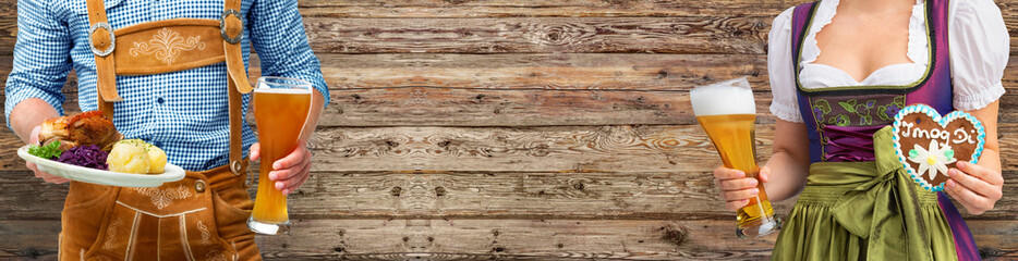 Woman and man in costume with beer glasses and Bavarian specialties