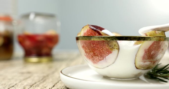Eating fig yogurt with wooden spoon 