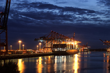 Fototapeta na wymiar Illuminated Container Ship / Freighter at Dusk / Night (Magic Ho