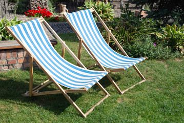 Deckchair chaise chair in café garden park gras, with blue red stripes relax