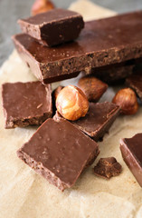 Dark chocolate and hazelnuts on a grey background.