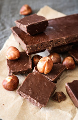 Dark chocolate and hazelnuts on a grey background.