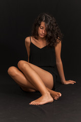 Fototapeta na wymiar Young brunette girl photographed in studio with black background