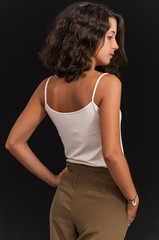 Young brunette girl photographed in studio with black background