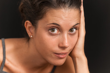 Young brunette girl photographed in studio with black background