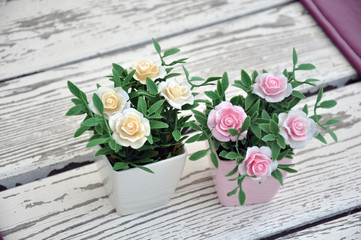 Artificial flowers in pots on the table.