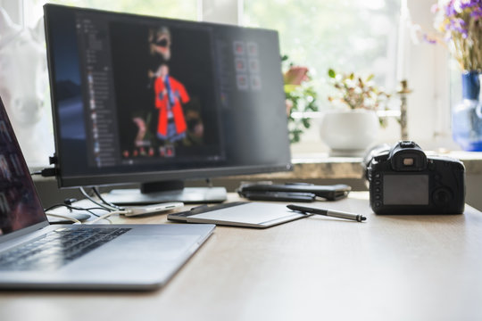 Photographer's workplace. Professional camera, computer and graphic tablet for editing images 