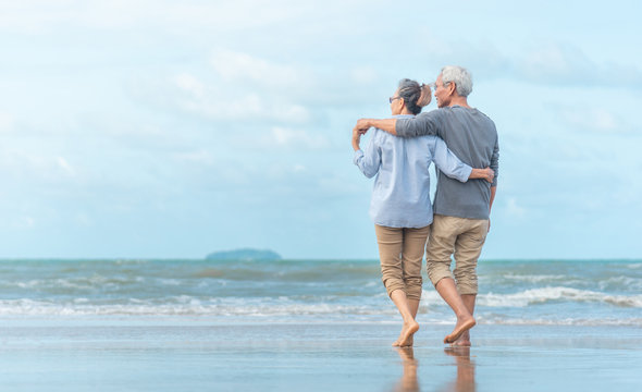 Happy senior couple on the beach. Exotic luxury resort.back view.