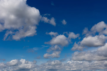 Fototapeta na wymiar Cumulus fluffy clouds in the blue sky. Harbingers of rain. Sky pattern. 