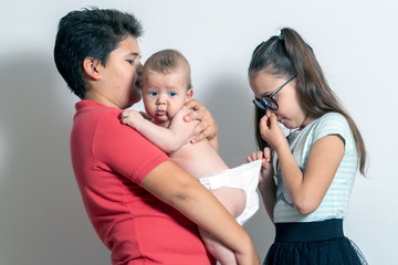 Children change the baby's diaper. Bad smell