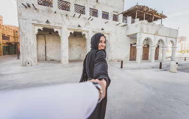 Happy couple spending time in Dubai. man and woman wearing traditional clothes making shopping in...