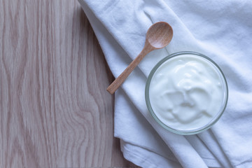 Natural homemade plain organic yogurt in bowl on wood texture background