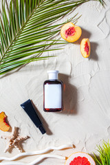 Safe sun. Skin care. A tube of cream lies on the beach sand, surrounded by vibrant fruits, corals,...