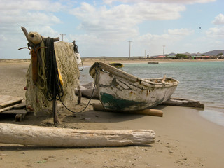 White and green wooden canoe and fishing net on the beach of Cabo de la Vela, La Guajira, Colombia