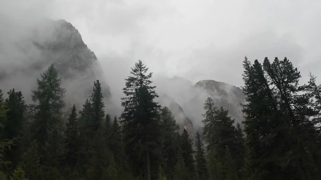Mountains engulfed in fog and clouds on a rainy day in Vallunga valley, Selva, South Tyrol, Italy.