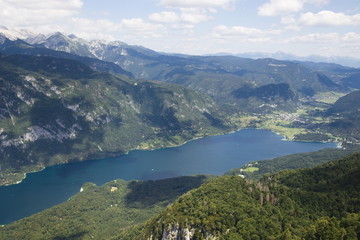 Fototapeta na wymiar View from above of Lake Bohinj and surrounding mountains, from sky lift and Mount Vogel
