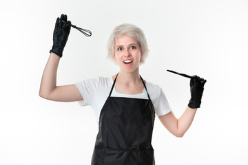 Pretty young hairstylist in a white tee and black apron holding color mixer and paintbrush standing isolated over white background.