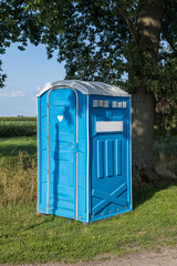 Portable toilet under a tree