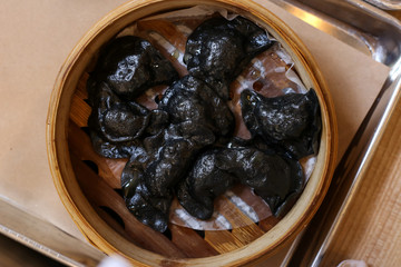 Black dumplings with filling. Dumplings, filled with cherry. Varenyky, vareniki, pierogi, pyrohy - dumplings with filling. View from above, top view