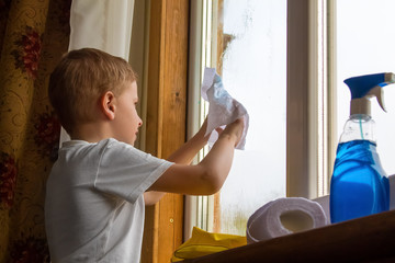 the boy in the yellow gloves washes a window