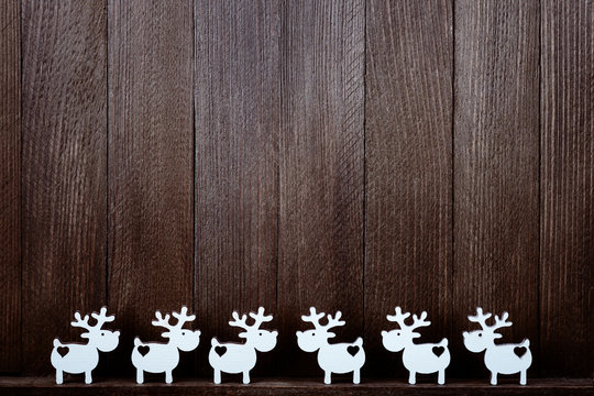 Composition of white reindeers on wooden background. Christmas decor