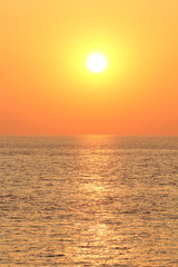 beautiful sunset at the westerschelde at a hot summer evening in holland with a deep orange sky