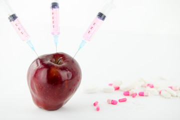Concept: human GMO manipulation of nature and relative poisoned fruits. Close-up of an apple...