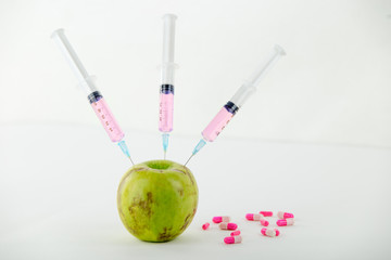 Concept: human GMO manipulation of nature and relative poisoned fruits. Close-up of an apple...