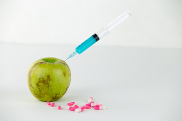 Concept: human GMO manipulation of nature and relative poisoned fruits. Close-up of an apple...