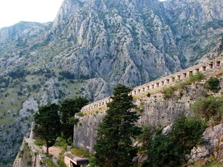 Obraz premium Landscape from the top of a mountain on the surviving walls of a medieval fortress surrounded by high inaccessible rocks covered with poor vegetation.