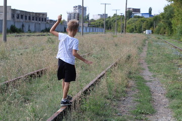 The child is on the rails of the railway danger